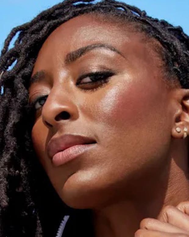 Nneka Ogwumike poses in a black one-piece and looks down at the camera.